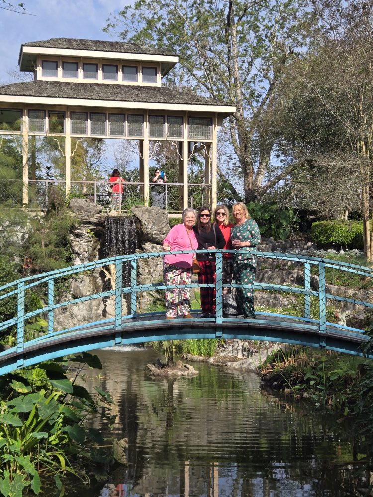 a group of people standing in front of a bridge