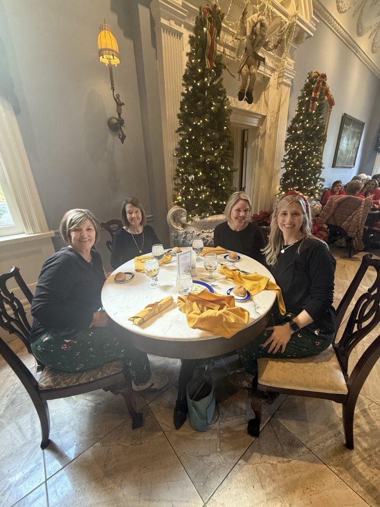 a group of people sitting at a table with food